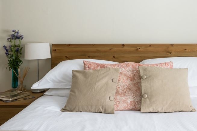 Freshly made bed with throw pillows. February Checklist